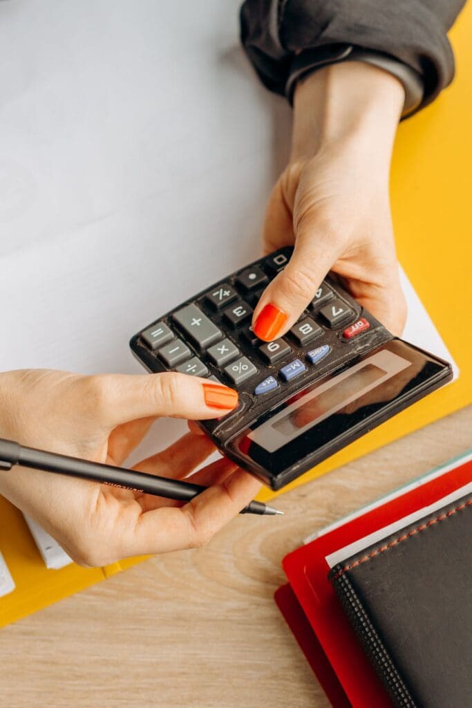 Person using a calculator to review disaster losses and tax records with a tax preparer Reno professional.